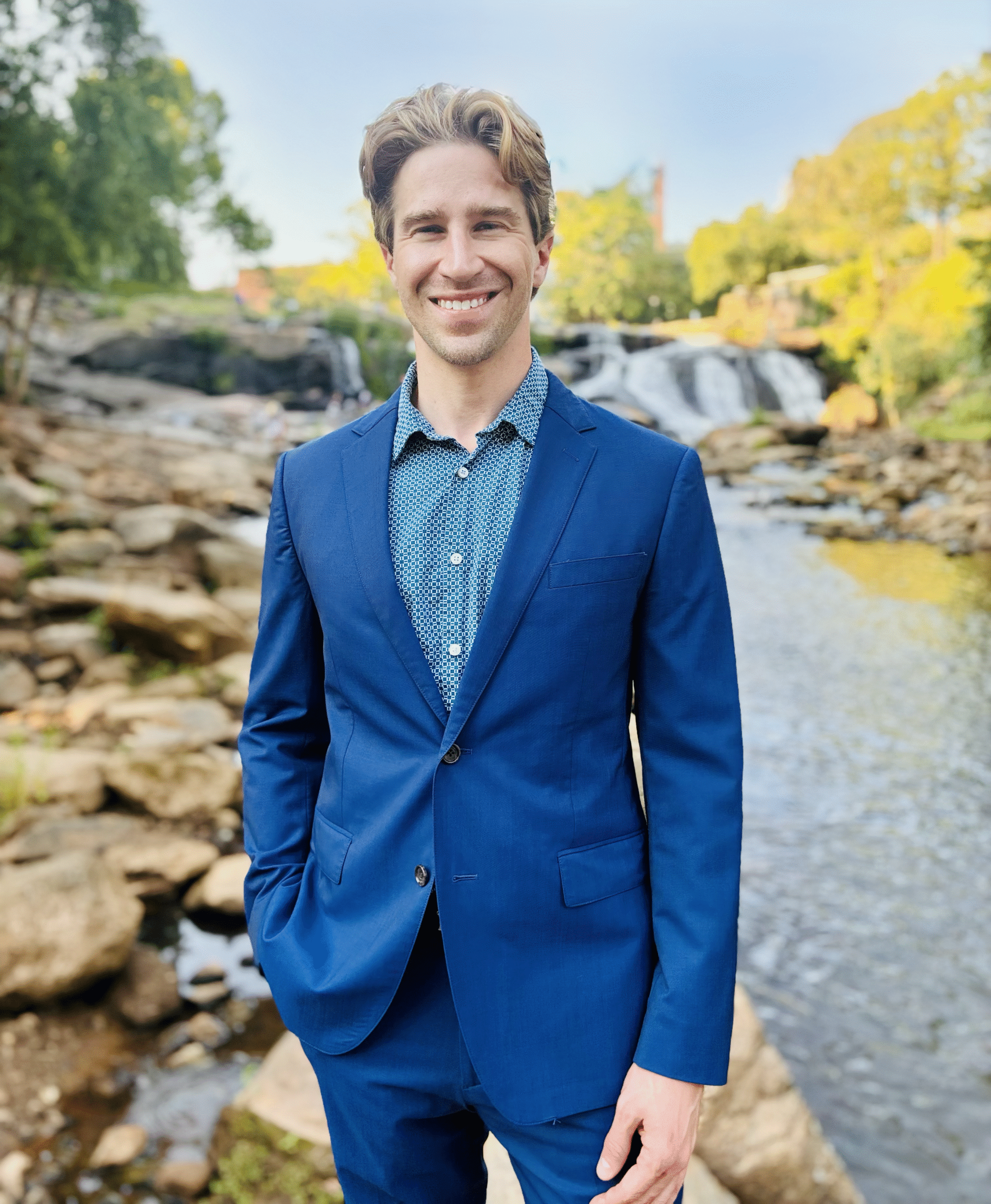 Dr. Aaron Dedmon standing in a blue suit in front of a river in South Carolina